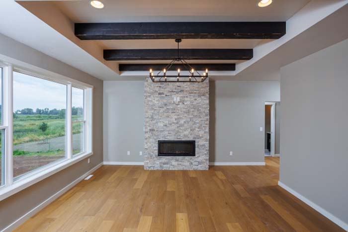 Living room with fireplace and vaulted ceilings with wooden beams 1903 Wizard Way